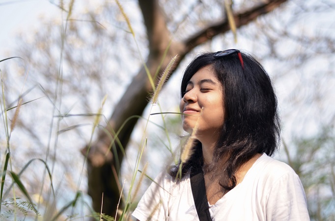 Woman outside taking a deep breath